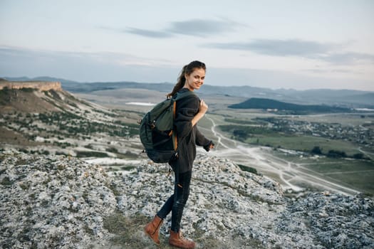 adventurous woman conquering the summit, gazing at the majestic valley below from high above