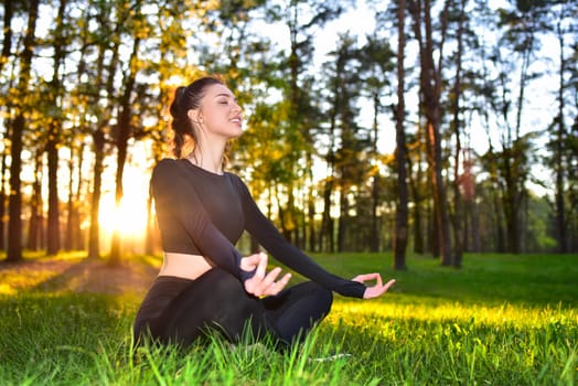 A young woman practices meditation in a serene forest during sunrise, promoting peace and mindfulness