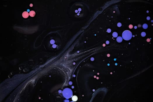 A myriad of oil droplets intermingling with water, creating a mesmerizing effect reminiscent of a galaxy.