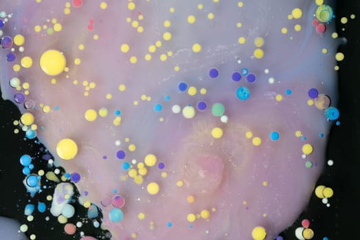 A myriad of oil droplets intermingling with water, creating a mesmerizing effect reminiscent of a galaxy.