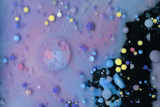 A myriad of oil droplets intermingling with water, creating a mesmerizing effect reminiscent of a galaxy.