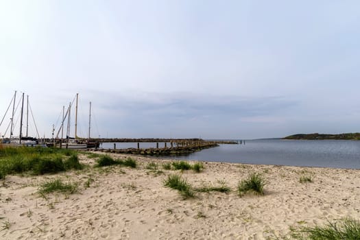 Sea pier with boats and yachts at sunset. Bornholm, Denmark - May 28, 2024. High quality photo