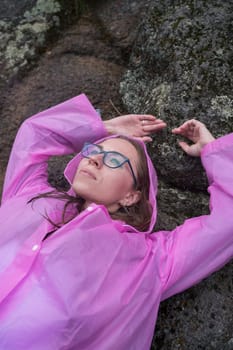 Woman in the raincoat the taiga forest and rocks of the Stolby nature reserve park, Krasnoyarsk, Russia