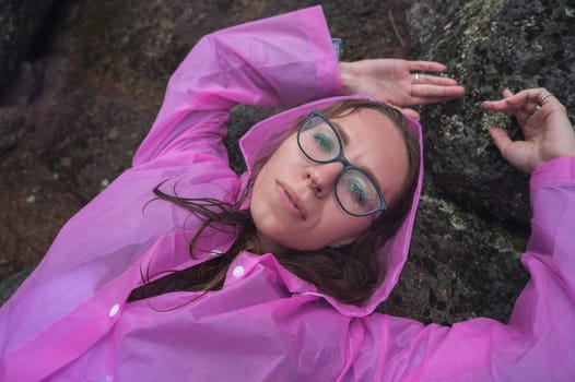 Woman in the raincoat the taiga forest and rocks of the Stolby nature reserve park, Krasnoyarsk, Russia