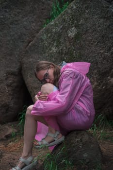 Woman in the raincoat the taiga forest and rocks of the Stolby nature reserve park, Krasnoyarsk, Russia