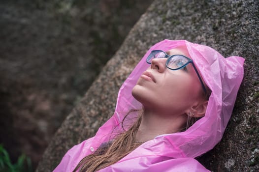 Woman in the raincoat the taiga forest and rocks of the Stolby nature reserve park, Krasnoyarsk, Russia