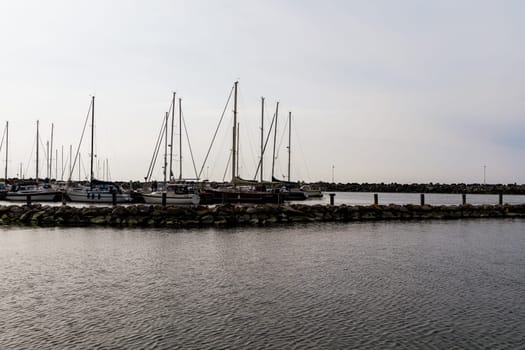 Sea pier with boats and yachts at sunset. Bornholm, Denmark - May 28, 2024. High quality photo