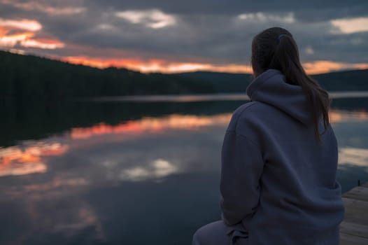 Woman sitting on the pier, closeup portrait, beauty summer sunset