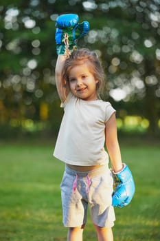 Charming child doing boxing in the backyard on the Sunset