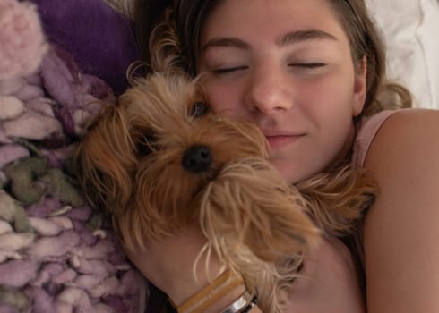 Little puppy and her owner cuddling in her room. Lifestyle.