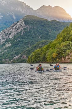 A group of friends enjoying having fun and kayaking while exploring the calm river, surrounding forest and large natural river canyons.