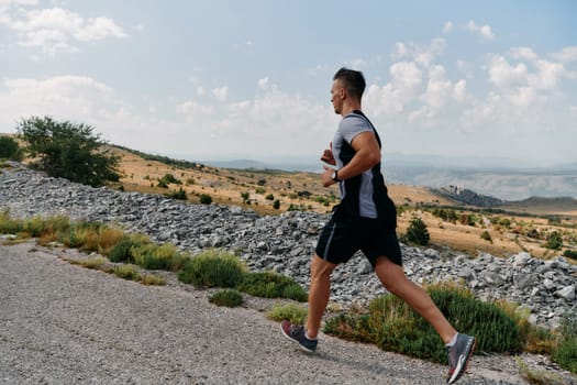 A muscular male athlete runs along a rugged mountain path at sunrise, surrounded by breathtaking rocky landscapes and natural beauty.