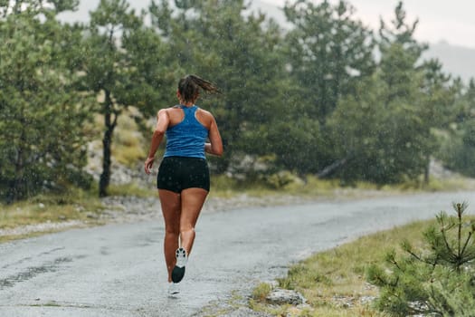 Rain or shine, a dedicated woman powers through her training run, her eyes set on the finish line.