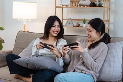 pride month Happy women lesbians lgbt couple spending time together at home in the evening, relaxing, playing game together in the living room. LGBTQ couple concept.