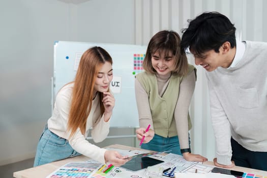 developer and ui designer brainstorming about mobile app interface wireframe design on table with customer breif and color code.