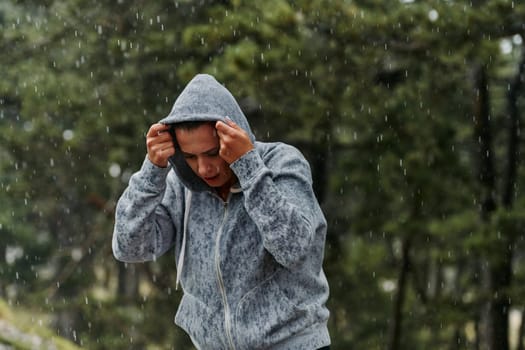 A stunning woman savors the tranquility of a rainy day after a rigorous run, finding solace and rejuvenation in the soothing rhythm of the falling rain.