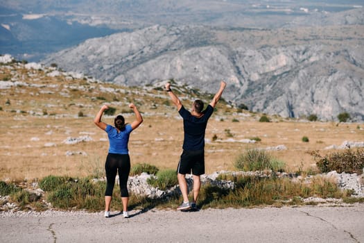 A jubilant couple celebrates their triumphant finish after a challenging morning run, exuding happiness and unity amidst the refreshing outdoor scenery.