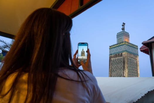 Woman Capturing the Beauty of Moroccan Architecture at Dusk