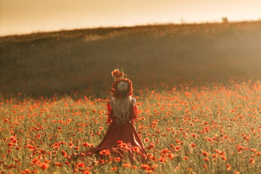 A woman in a red dress stands in a field of red flowers