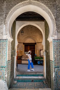 Young Woman Walking Through Bou Inania Madrasa Exit Archway, Fez, Morocco