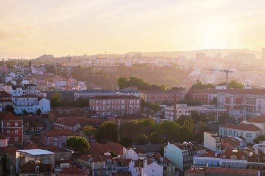 View of Lisbon famous view from Miradouro da Senhora do Monte tourist viewpoint in contre-jou on sunset. Lisbon, Portugal