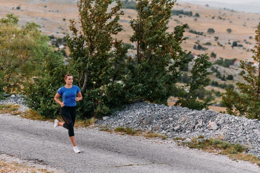 A determined female athlete runs through a forest trail at sunrise, surrounded by breathtaking natural beauty and vibrant greenery.