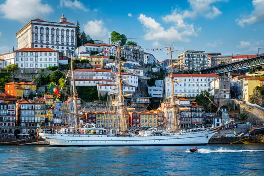 View of Porto city and Douro river with sailing ship from famous tourist viewpoint Marginal de Gaia riverfront. Porto, Vila Nova de Gaia, Portugal