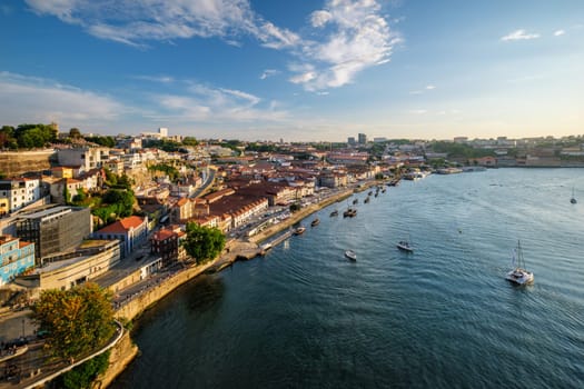 View of Vila Nova de Gaia city and Douro river with tourist boats on sunset. Porto, , Portugal