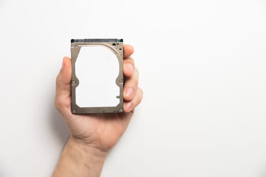 Man's hands showing a hard drive from a desktop computer close-up on a white background.