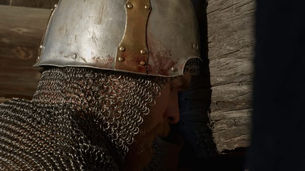 Medieval old knight helmet and chain mail for protection in battle. Media. Close up side view of a man in very heavy headdress, middle ages armor concept