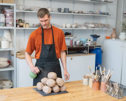 The potter wets the clay before using it in the workshop