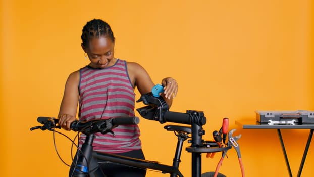 Engineer setting up bike repair stand, using it to adjust derailleur and cables, fixing broken wheels, studio background. Professional assembling workstand to maintain bicycle at eye level, camera B