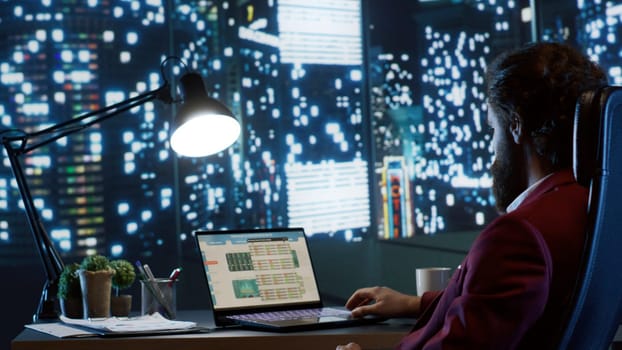 Rich executive director admiring skyscraper view at night, working after hours to improve company financial situation. Professional business expert looking for ways to expand globally.