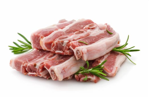 Several slices of raw pork ribs garnished with fresh green rosemary sprigs arranged on a plain white surface.