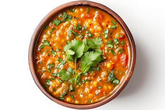 A bowl filled with spicy lentil dahl soup, topped with vibrant green cilantro leaves for a pop of flavor and color.