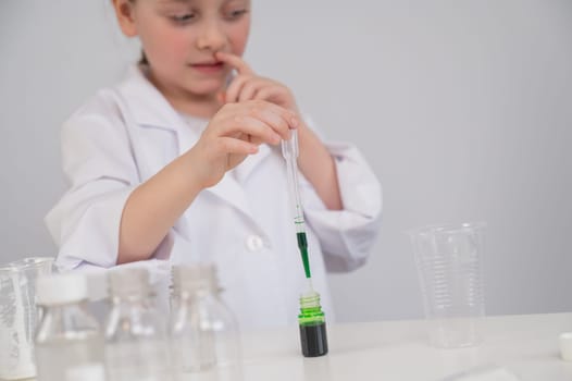 Caucasian girl doing chemical experiments on a white background