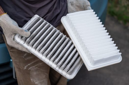 The master changes the air filter in the car engine