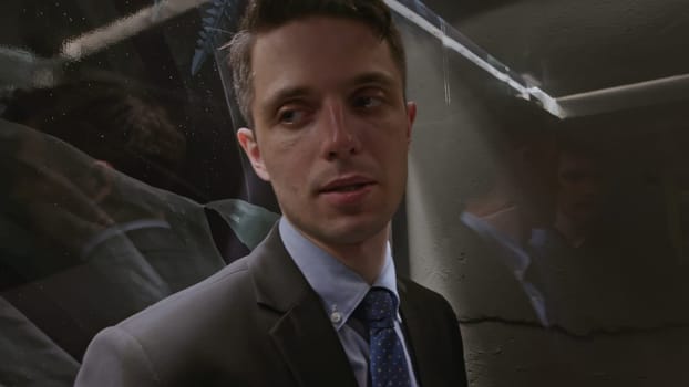 Business partners entering the glass facade elevator. Stock clip. Two young men in elevator, close up communication