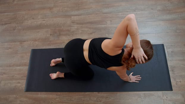 A woman from a knee elbow position making the bends of the body. Media. Concept of sport and body care