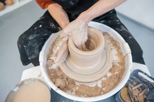 Close-up of a potter's hands working on a pottery wheel