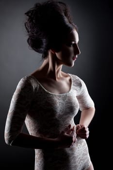 Studio portrait of brunette posing in lace bodysuit like doll