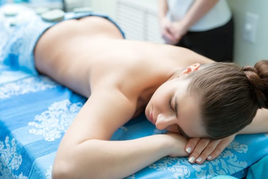 Spa massage. Image of young girl lying on her stomach