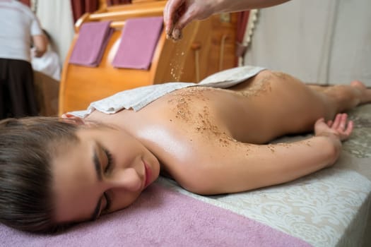 Spa massage. Image of young girl lying on her stomach
