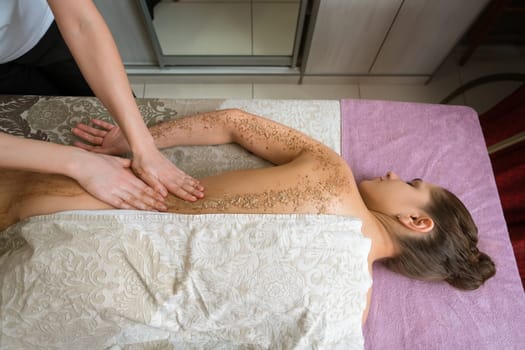 In spa salon. Top view of girl getting procedure body scrub