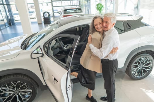 Mature Caucasian couple hugging. Elderly man and woman buying a new car