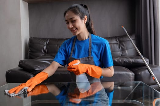 Person cleaning glass table with spray and cloth. Concept of housework and cleanliness.