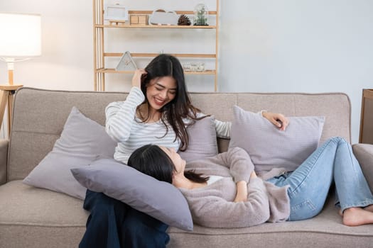 Two young women relaxing on couch at home. Concept of friendship and comfort.