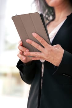 Portrait of a smiling middle-aged business woman with digital tablet in smiling hands looking at camera