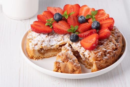 Fruit cake decorated with strawberries and blueberries.