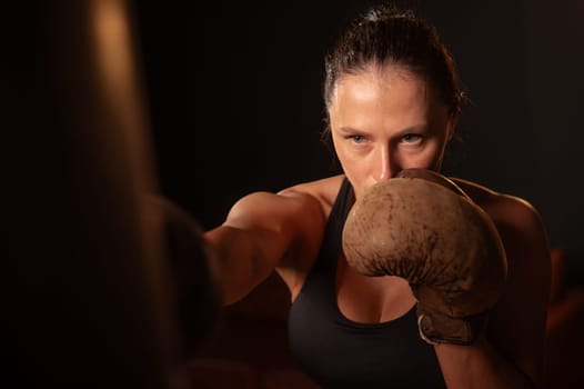 Caucasian woman boxing in retro gym